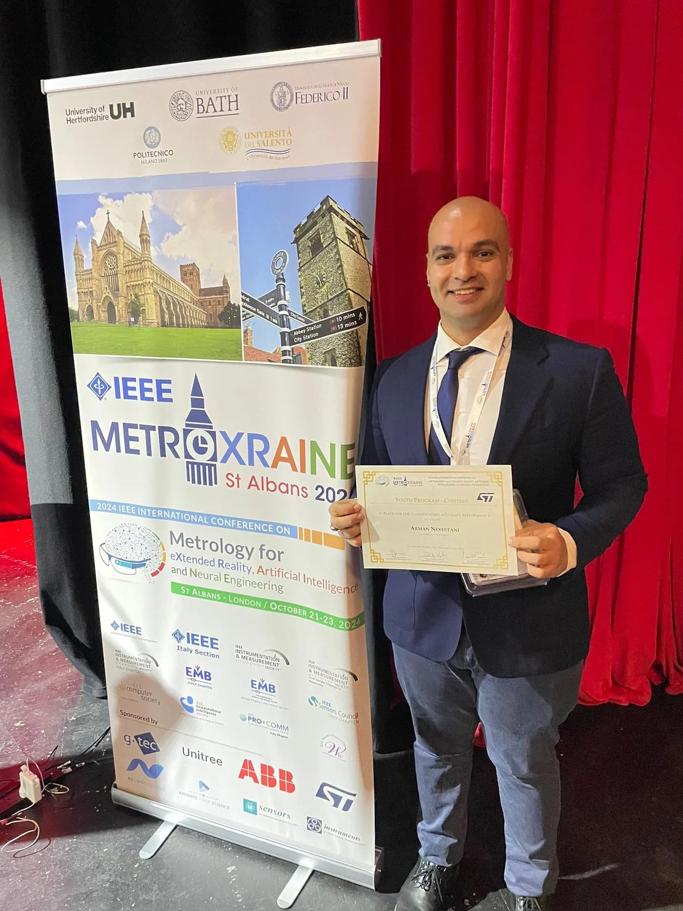 Arman Neyestani holding the MetroXRAINE first-place certificate.